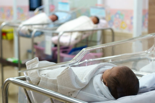 Photo showing a newborn in a hospital baby bed